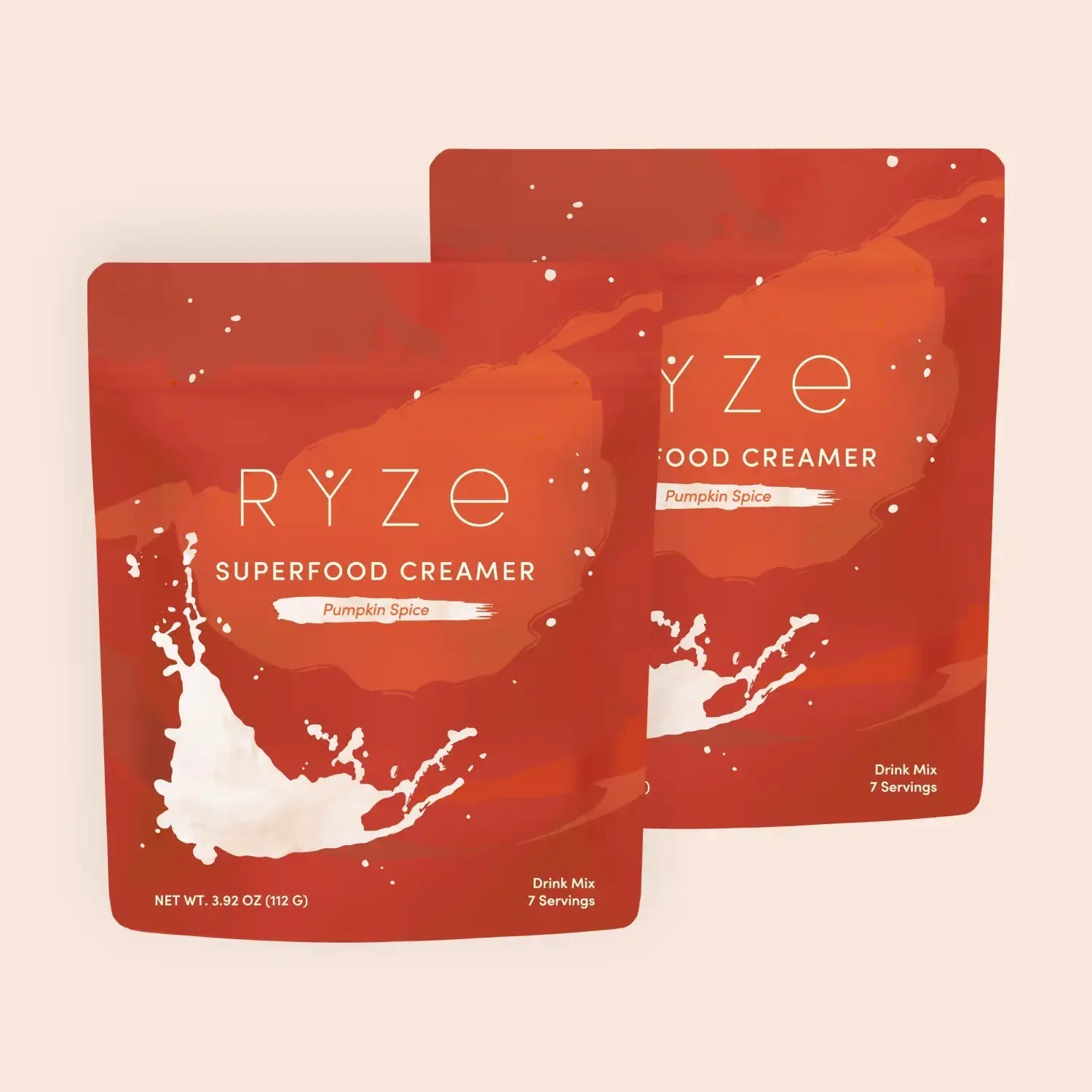 RYZE pumpkin spice superfood creamer packets with milk splash on orange-red background